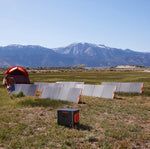 Jackery Explorer 2000 Pro gekoppeld aan 6 draagbare zonnepanelen naast een tent