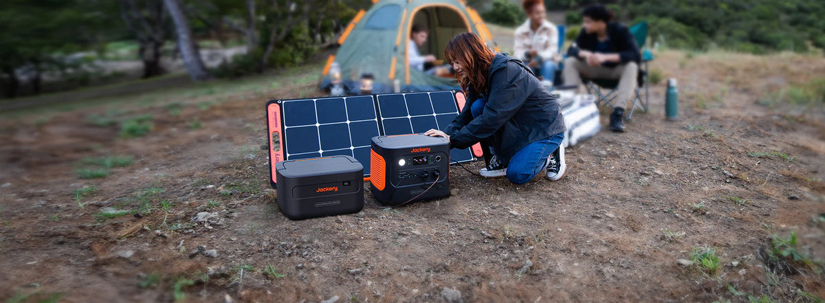 vrouw sluit Jackery Explorer 1000 Plusaan op zonnepaneel en extra batterij