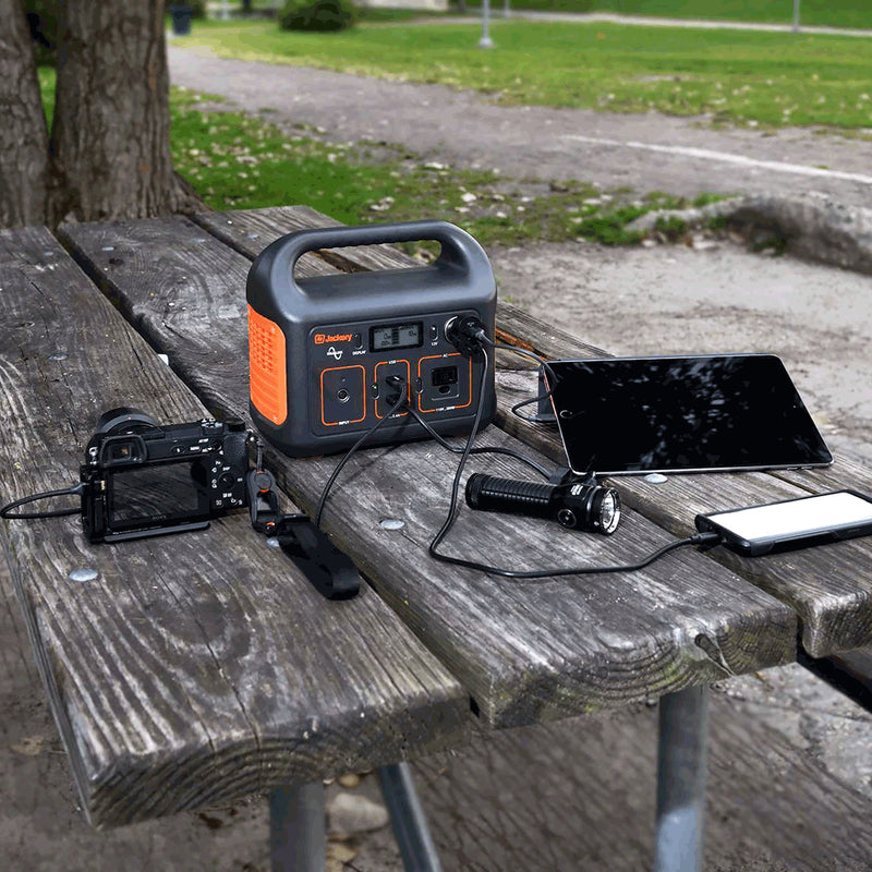 Jackery Explorer 240 die een tablet, camera en smartphone aan het opladen is